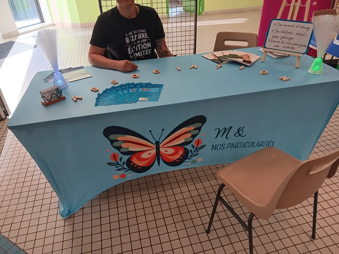 Stand de M& nos particularités avec nappe bleue et logo papillon